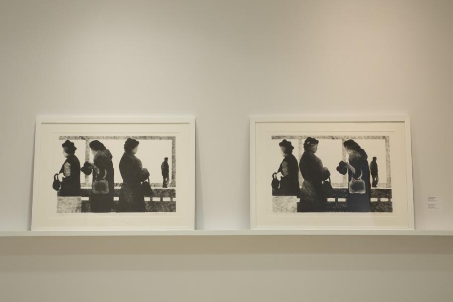 Two black-and-white prints of silhouetted figures displayed side by side on a ledge.