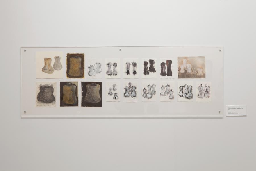 A wall-mounted series of drawings depicts repeated vessel forms in varied textures and tones.