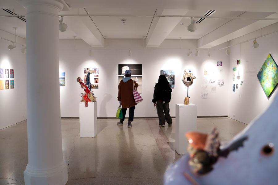 Visitors viewing artworks and sculptures inside the School of Art Student Gallery during an exhibition.