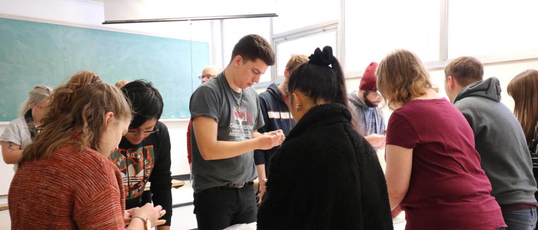 Students looking at artifacts in a classroom.