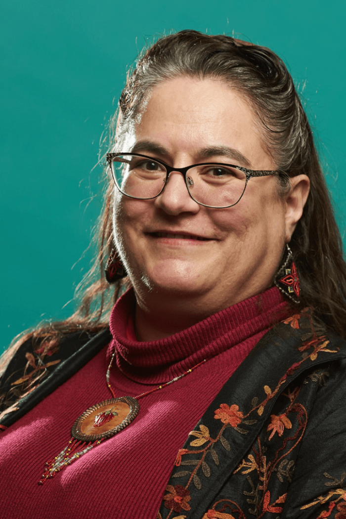 Headshot of Cary Miller with teal background.