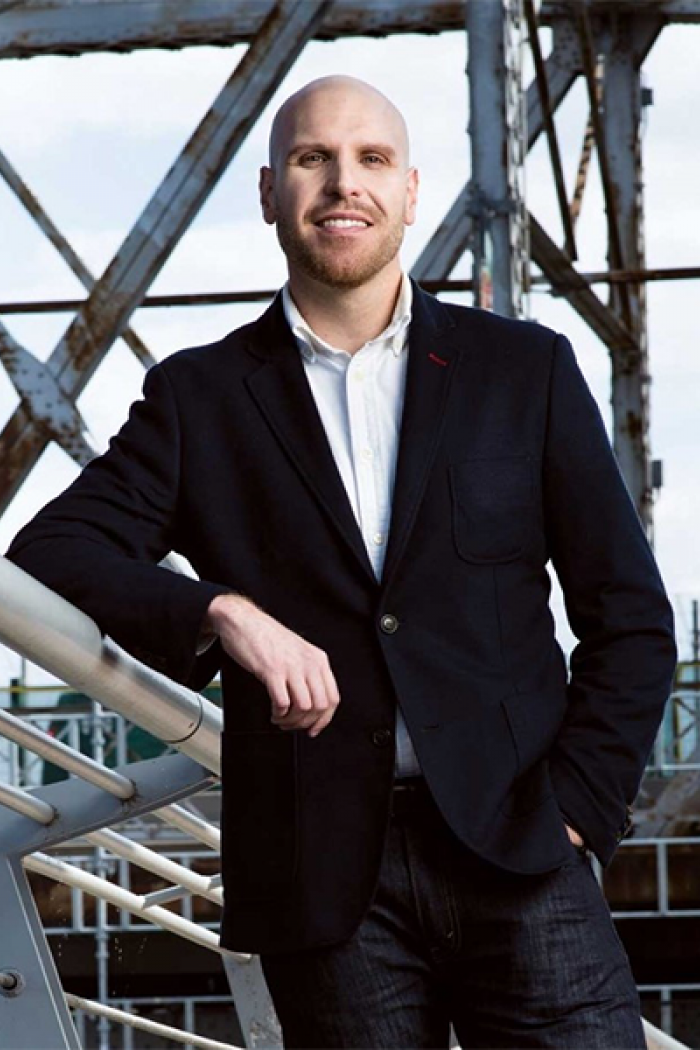 Sean Carleton standing in front of beams and glass.