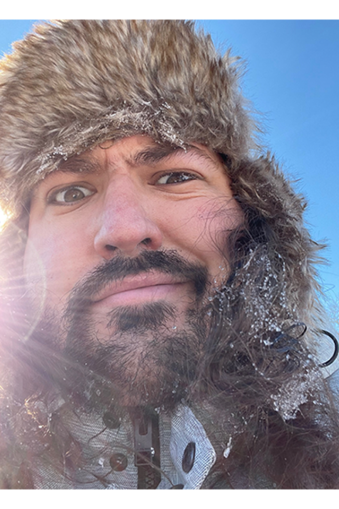 Headshot of David Parent looking into camera with fur hat on.