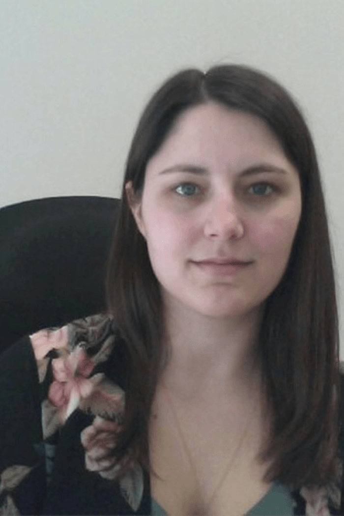 Headshot of Labour Studies alumni Gwen Suprovich sitting at desk chair.