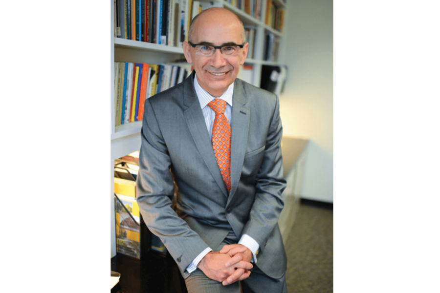 The Dean of Arts Jeffery Taylor sits in his office, smiling.