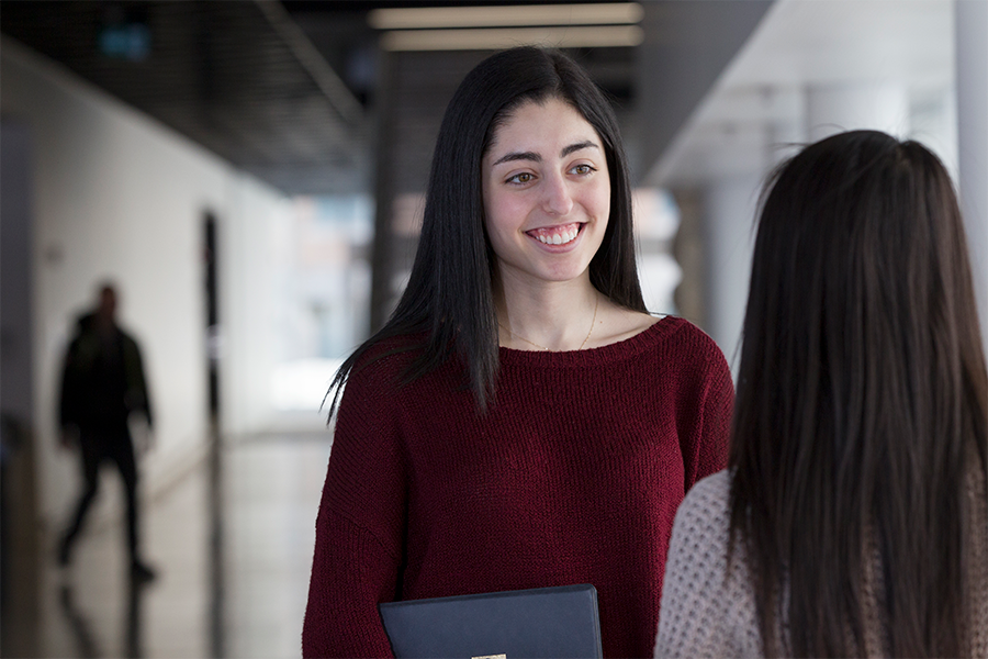 A student talking to a classmate at a hallway.