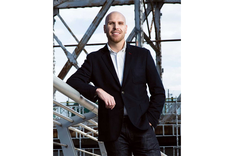 Sean Carleton standing in front of beams and glass.