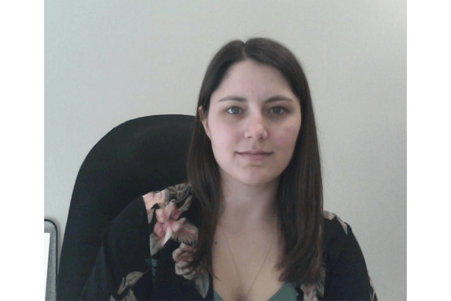 Headshot of Labour Studies alumni Gwen Suprovich sitting at desk chair.