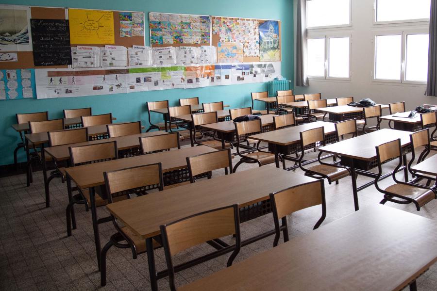 Empty classroom with rows of desks.