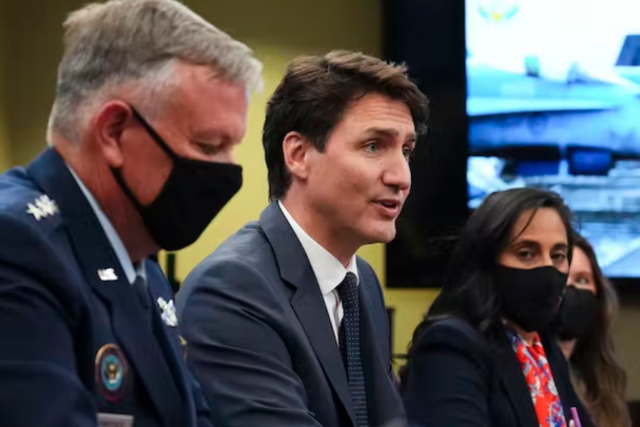 Justin Trudeau presenting with military and civilian speakers at a NORAD event.