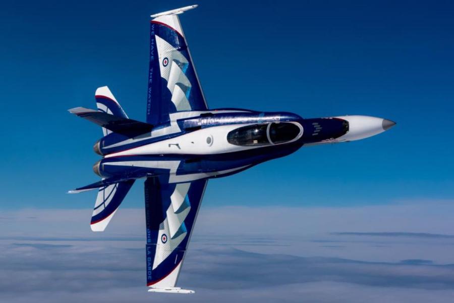 F-18 airplane flying with blue sky backdrop.