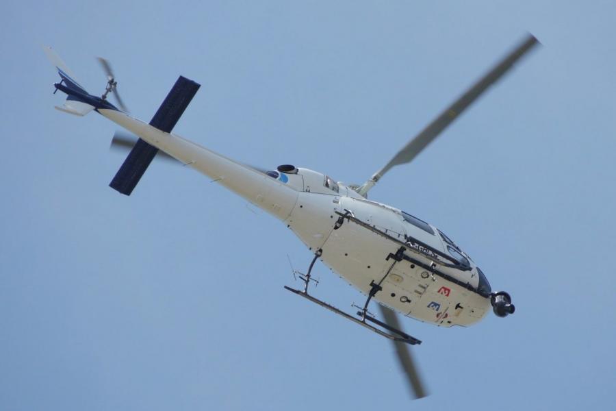 View of the underside of a helicopter as it flies overhead.