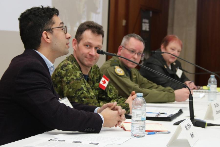 Four person panel, two in suits, two in military uniform. 