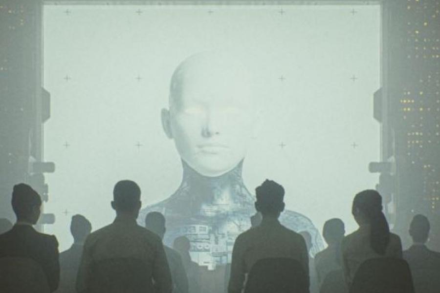Silhouette of a crowd looking at a robot on a large screen.