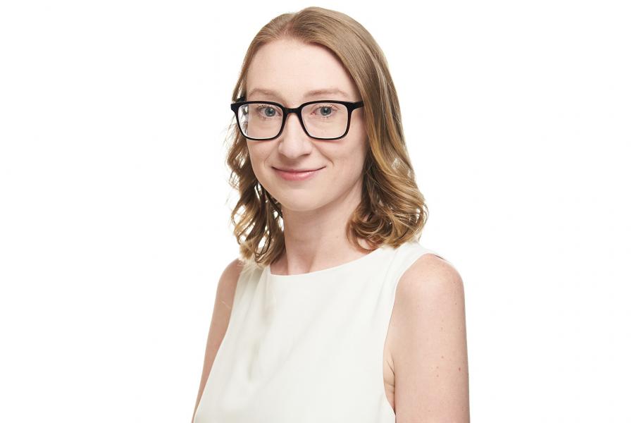 Headshot of Alex Goodman wearing glasses and white sleeveless top.