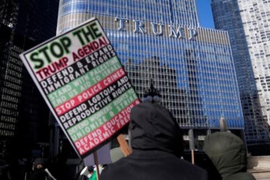 Protestors marching and holding signs outside of Trump tower in New York city.