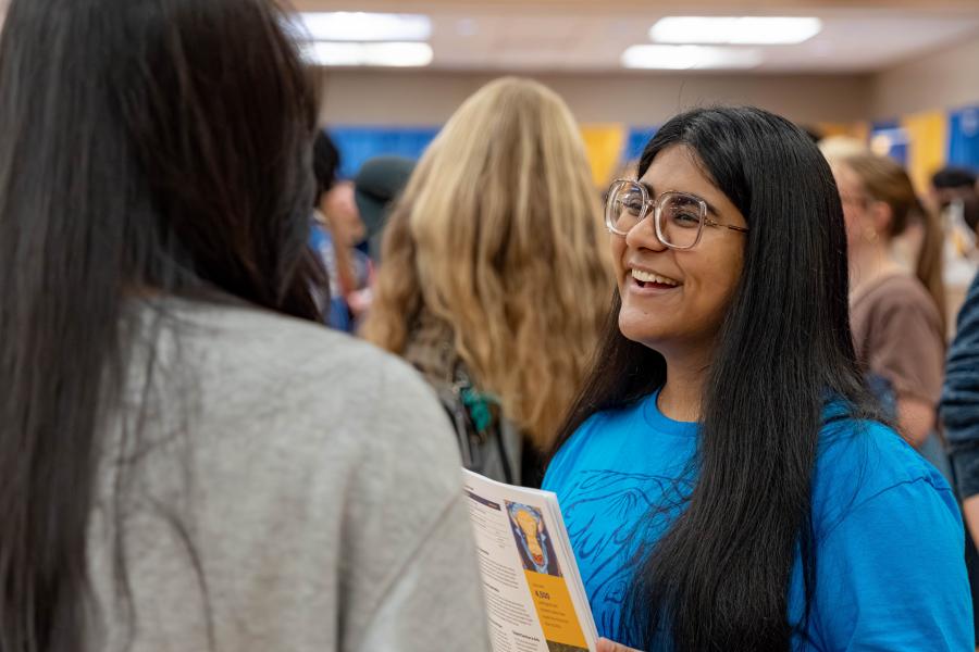 Arts Student Ambassador talking to a prospective student at a recruitment event.