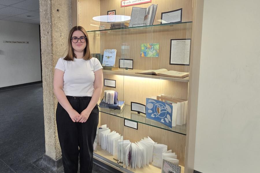 Natasha standing next to a cabinet filled with student work.