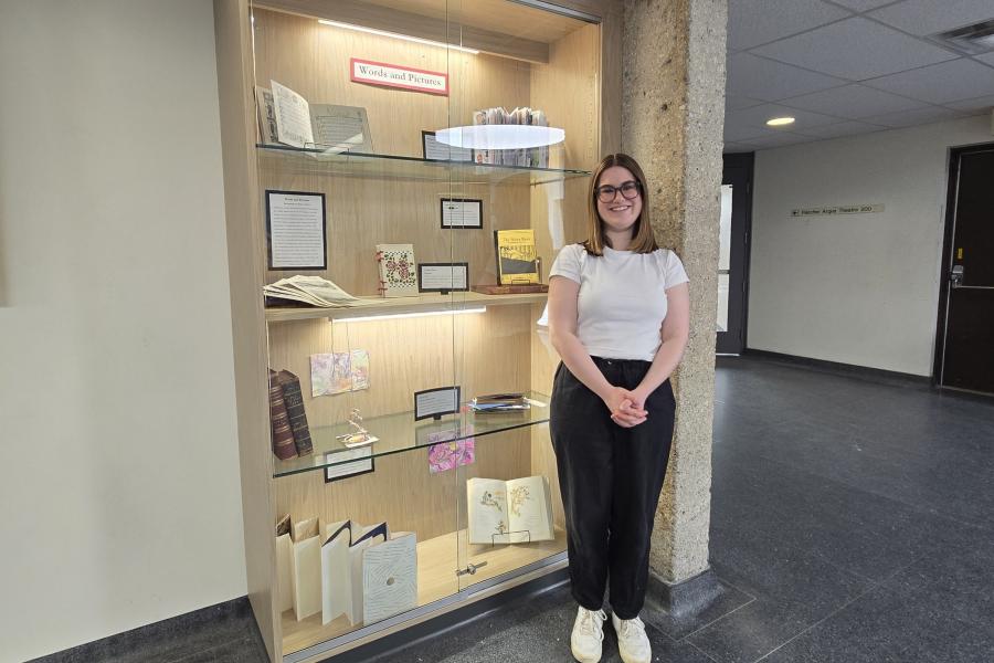 Natasha standing next to a cabinet filled with student work.