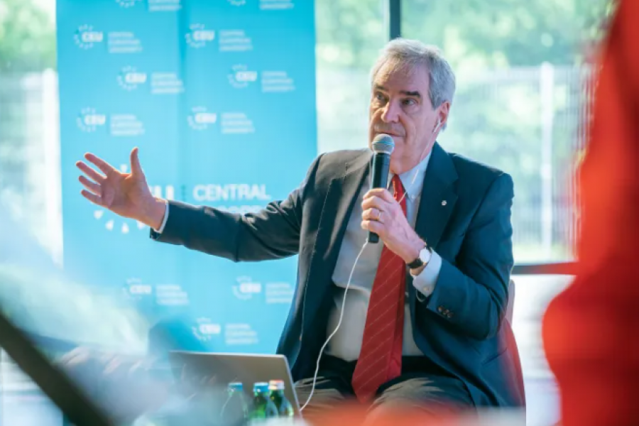 Michael Ignatieff holding a microphone to his mouth, with his other arm outstretched as he speaks to a crowd.