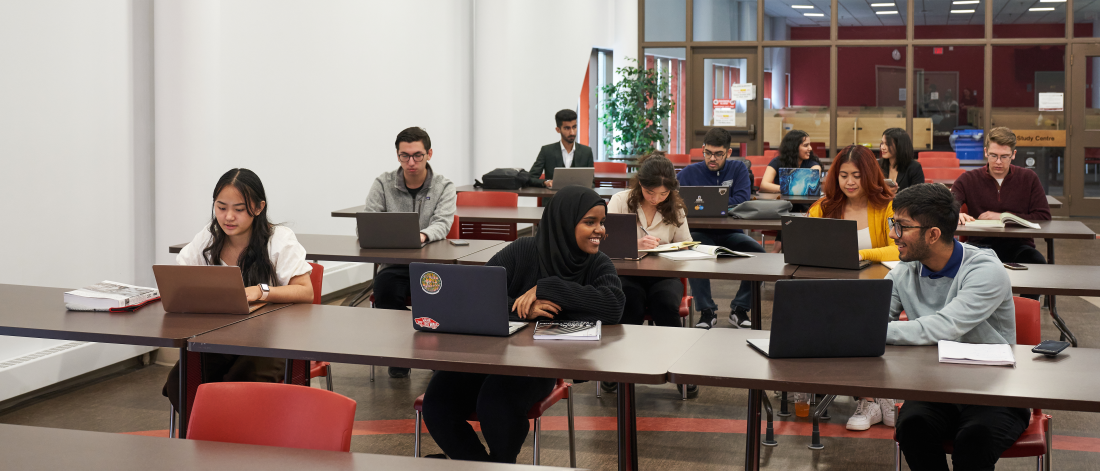 Several students studying at tables at the Asper School of Business.