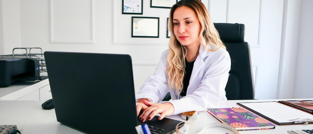 Physician typing on laptop