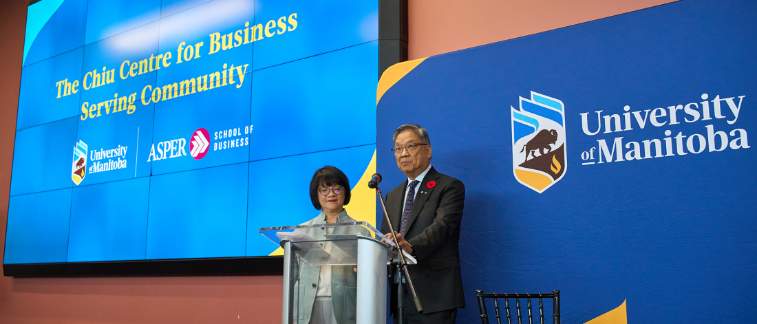 Two people standing at podium giving speech.