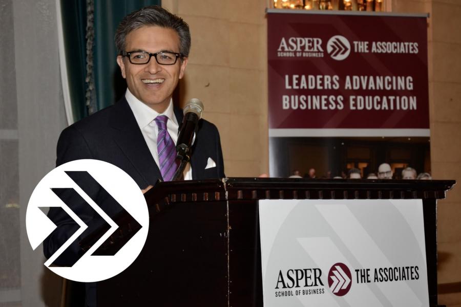 An Asper Associate stands at a podium during an event.