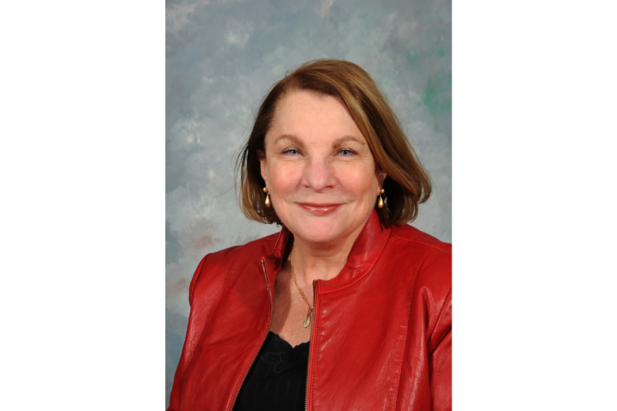 Dr. Mary Brabston's professional headshot. She is wearing a lovely red jacket