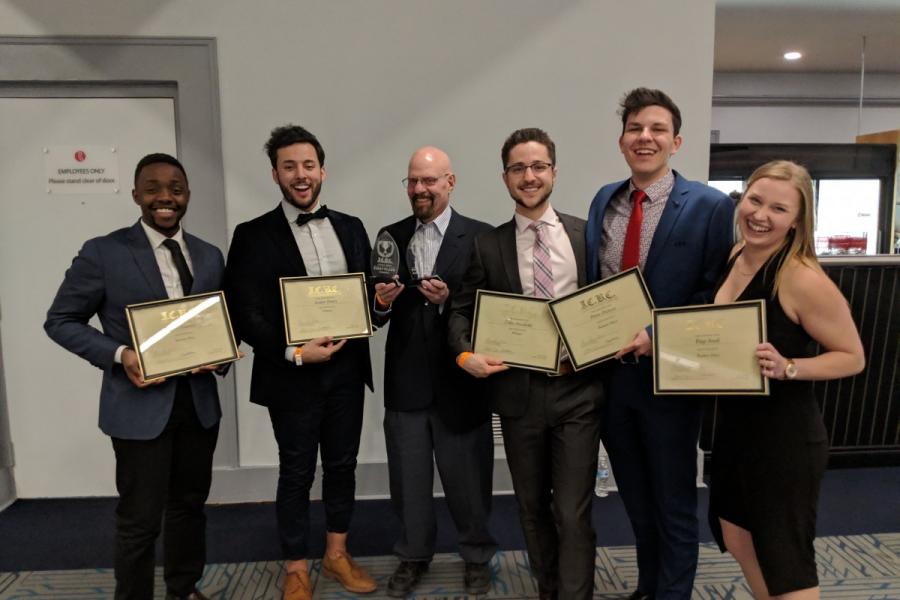 photo of a group of students and their coach winning a case competition