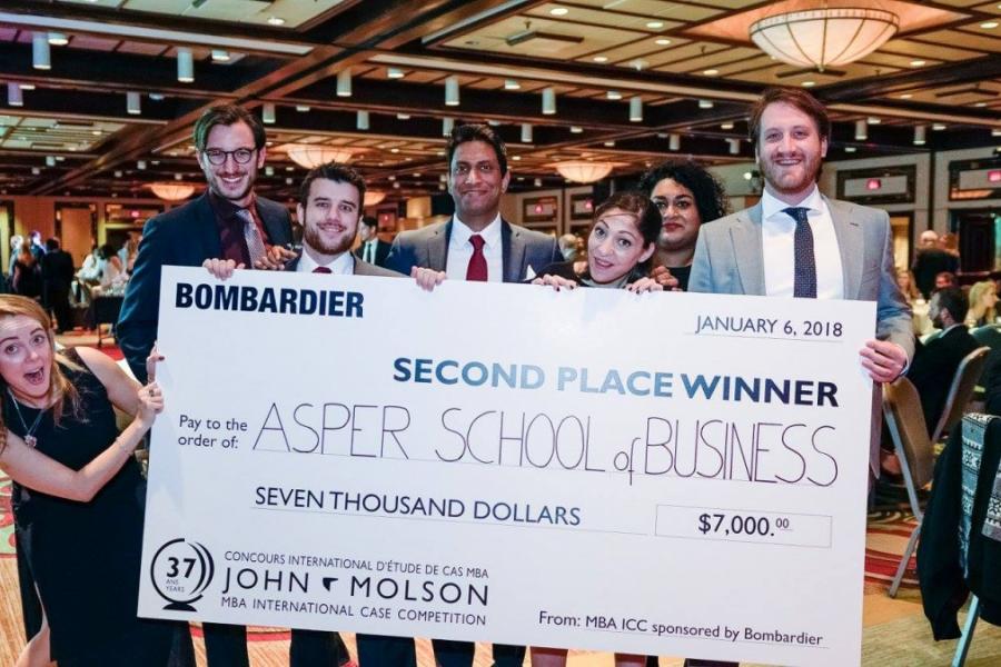 a photo of Asper graduate students holding a big winning cheque