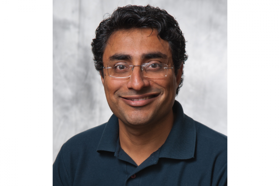 portrait of professor Sandeep wearing a dark blue polo shirt. He is smiling.