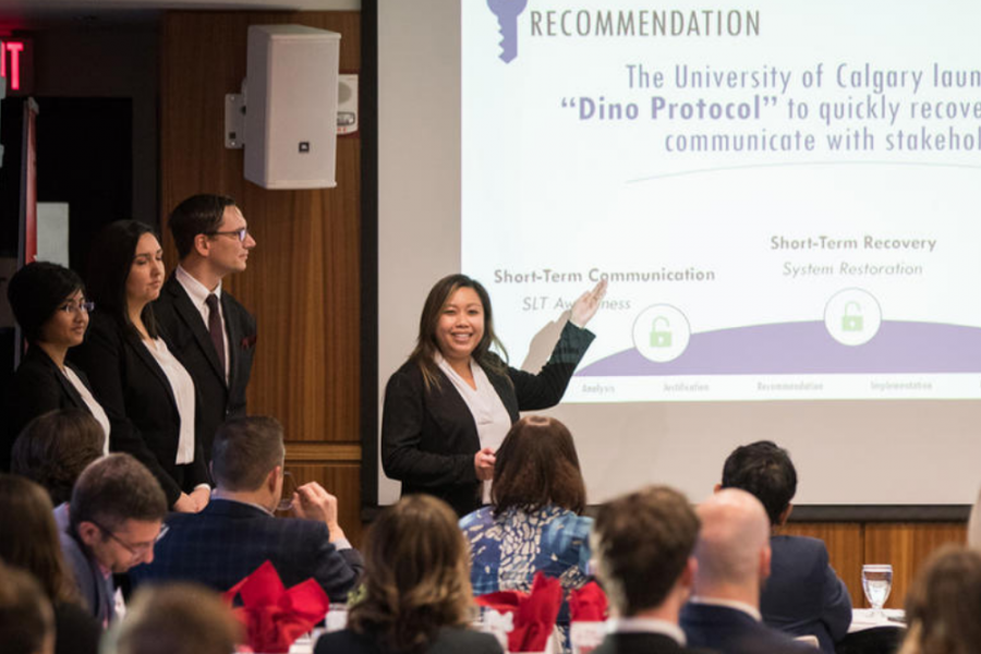 a female graduate students presenting her business case in front of a crowd