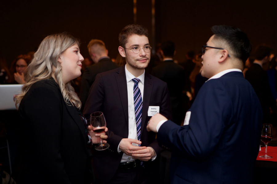 three students discussing at a business dinner