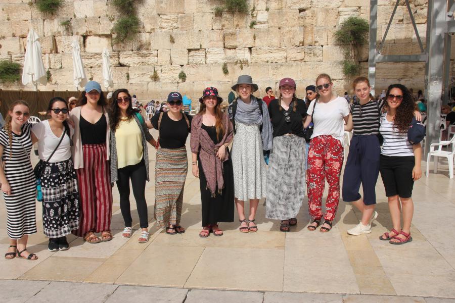 8 women standing in front of the Western Wall.