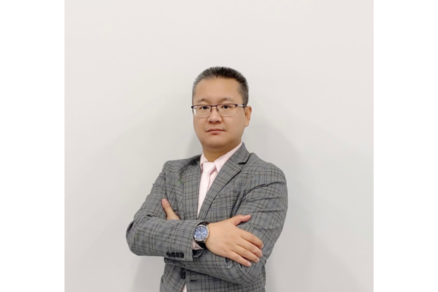 Man in suit standing in front of a wall.