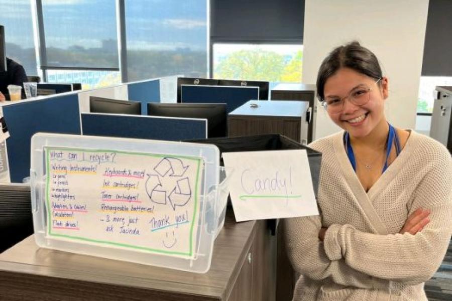 Girl standing with a poster that speaks about recycling