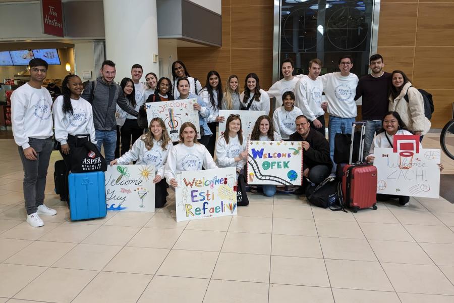 Students wearing matching white sweatshirts at the Winnipeg airport