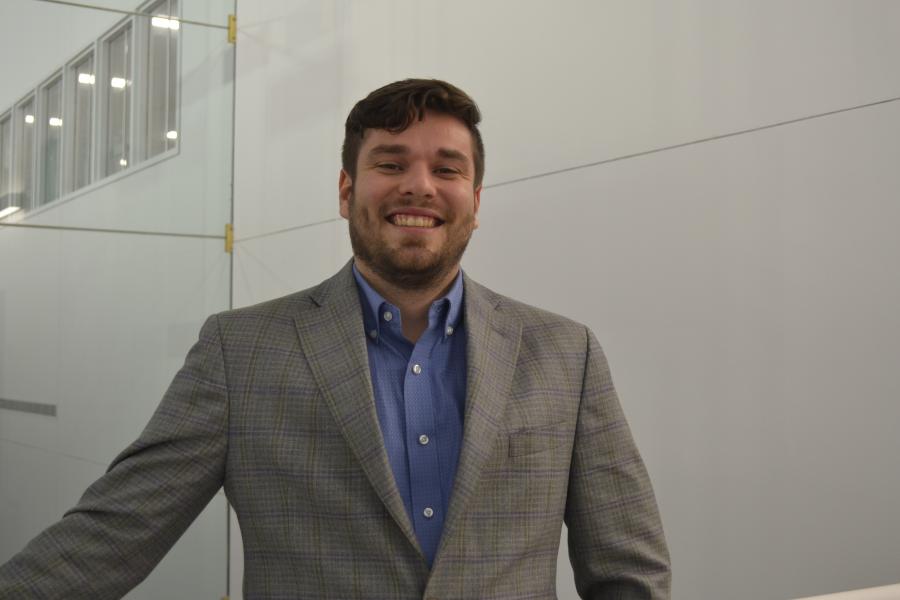 Man smiling in grey suit. 