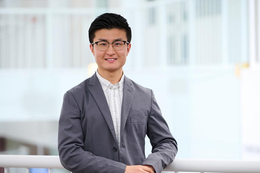 Image of man in light grey suit and glasses.