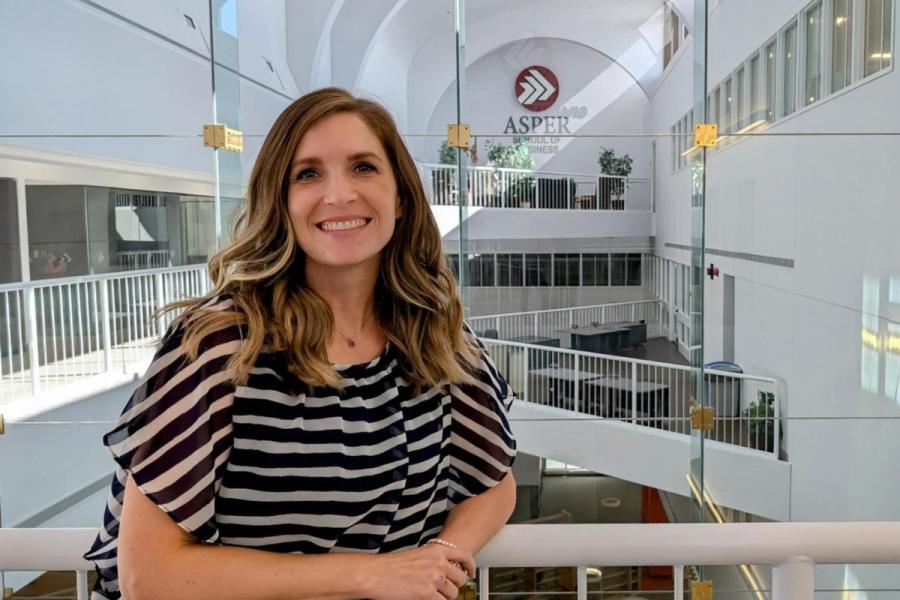 photograph of a women smiling in the atrium of the Asper School of Business
