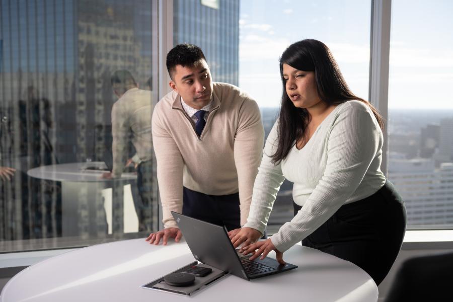Two students standing at laptop presenting