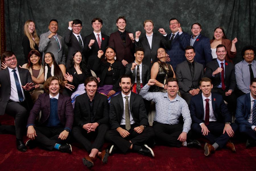Group of Indigenous students from the Asper School of Business wearing business clothes cheering.