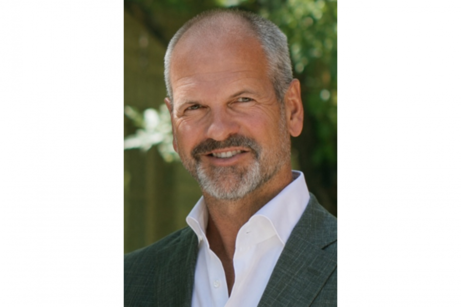 Image of a man in a grey suit and a beard.