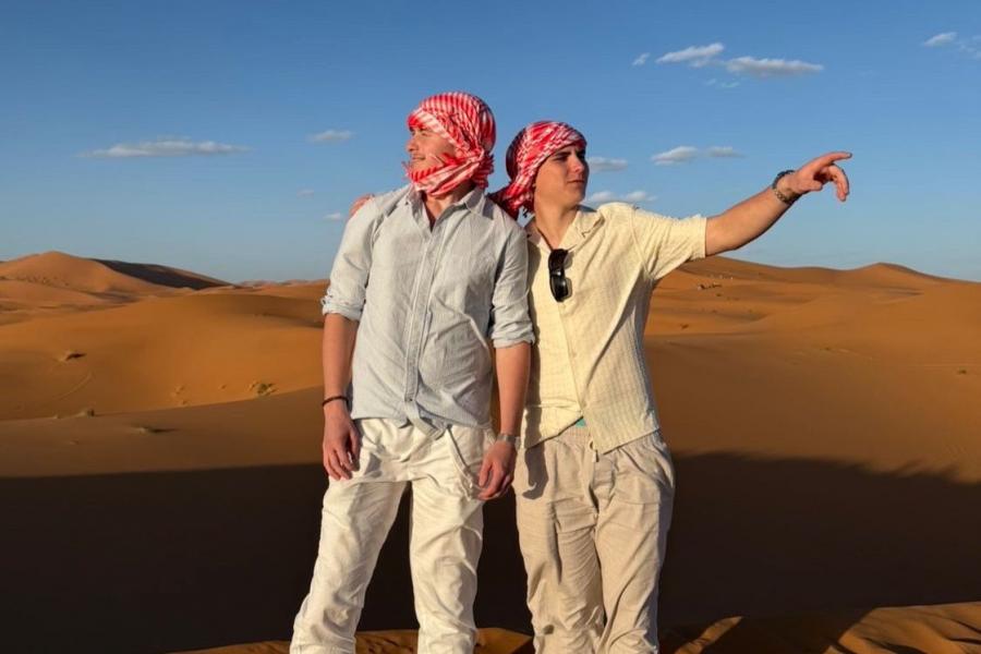 Two young men standing in a desert