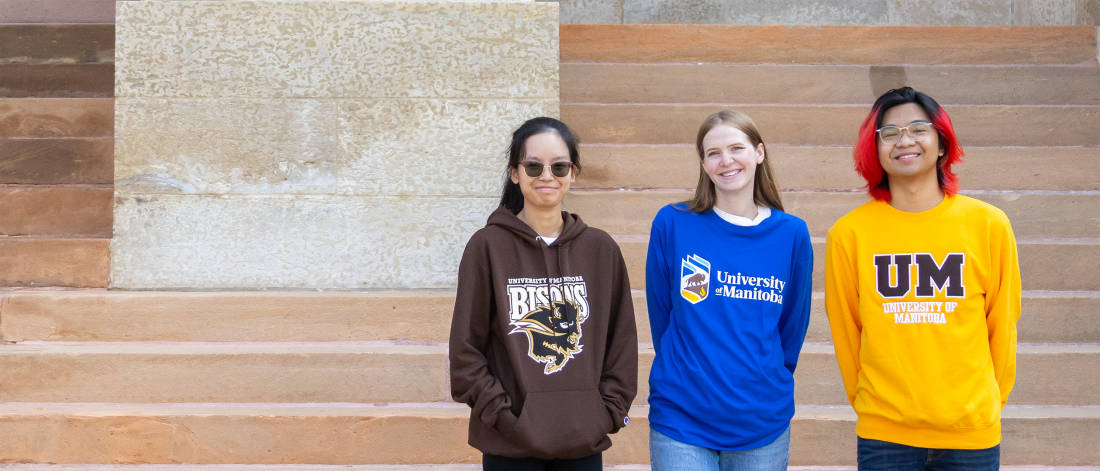 3 students wearing University of Manitoba and Bisons clothing