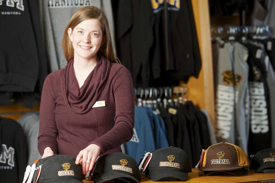 A staff member organizes bisons-branded hats at the fort garry bookstore.