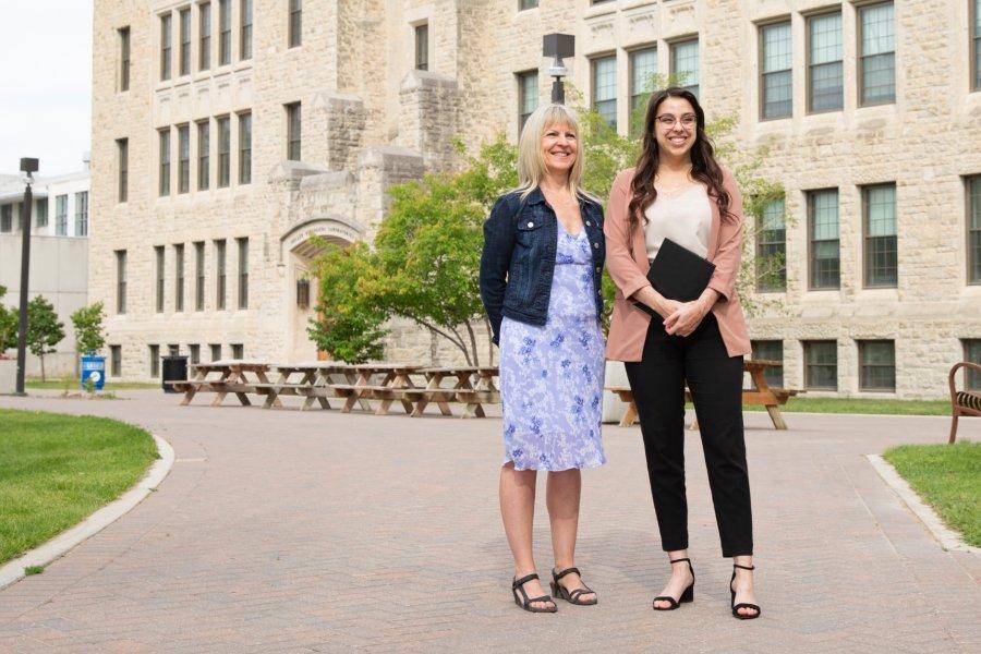 Career mentor Angelal stands with an international student outdoors in front of the Buller Biological building.