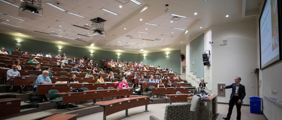 Profess gives a presentation in a large lecture theatre.