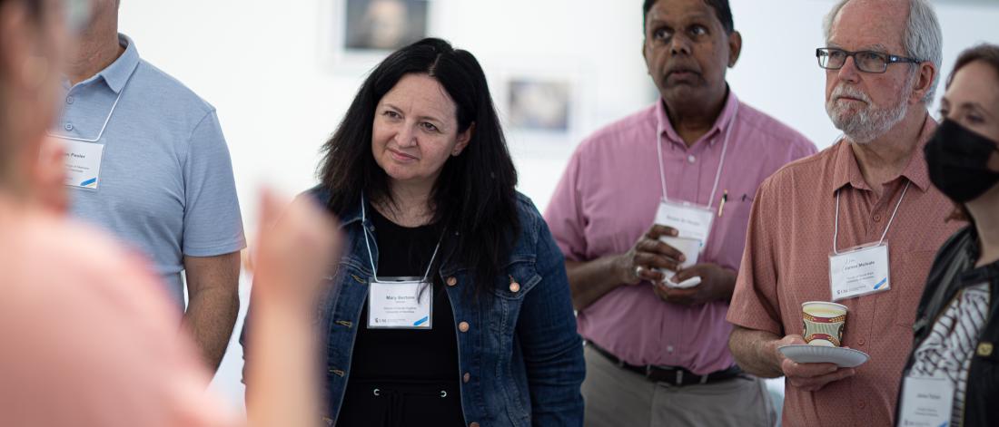 Attendees at the SoTL Symposium 2023 stand and listen to a presentation.
